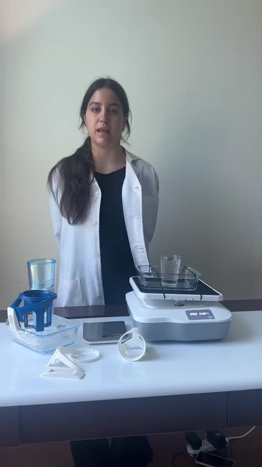 Selin in a lab coat explaining her ONiLAB rocking shaker test setup.